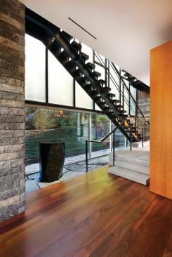 The metal staircase with massive ebonized oak treads can be seen from the first floor of the home.