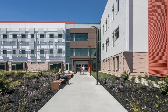 The exterior walls have a rusticated base to ground the building in the landscape. Bold color fins provide places for skyline signage and create interest at the end of each wing.