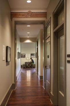 The central corridor of the original building now runs straight through the addition. On the second floor, the corridor was extended through an old window in the original building. The exterior window hood was saved and can now be viewed from the corridor in the addition.