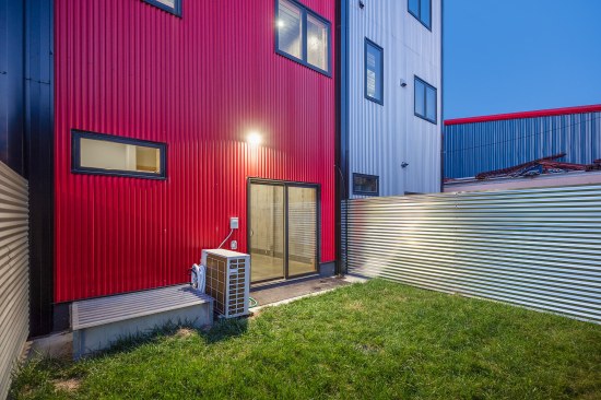 Backyard with basement window well egress, corrugated galvanized steel fencing, green space