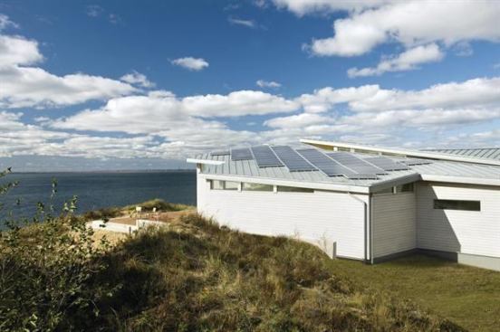 EcoHome Design Awards, Summer 2010  Grand Award  ZeroEnergy Design   On this sunny bluff overlooking Cape Cod Bay, 11.7 kW of solar panels on the south-facing roof gather much of the home's required energy.