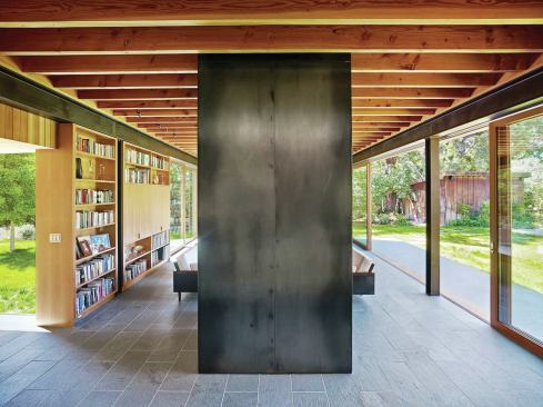 The chimney is clad in hot-rolled steel, matching the exposed structural beams.