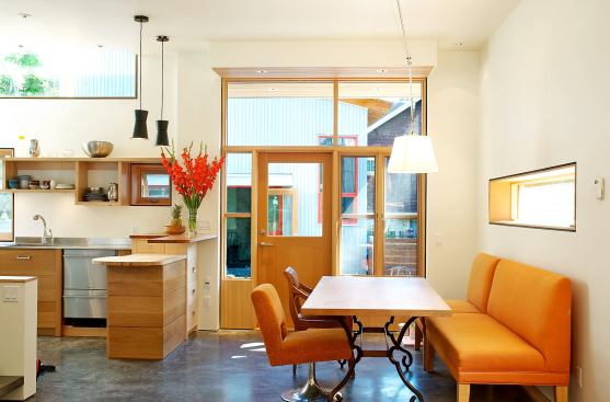 The dining area is adjacent to the kitchen and looks out onto the courtyard and laneway house beyond.