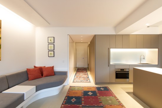 A built-in sofa makes the most of a small living space that is open to the foyer and the kitchen.
