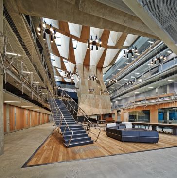 The atrium features a faceted wooden structure called the Suspended Studio.