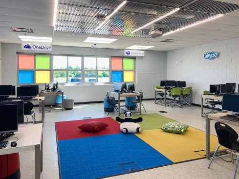 The 1990’s computer lab at Arbor Park Middle School became the 21st century Microsoft Dock Lab by re-thinking its purpose. Physically, all it took was paint, a partial replacement of the floor tile with colored carpet tile, and partial replacement of the ceiling with clear Ceilume ceiling panels.  The new docklab allows students to plug their tablets into a bigger screen with a keyboard and mouse, or to just sit on the floor and use the tablet by itself. The lighting is a little less intense in the central area under the clear ceiling to prevent glare on the tablets. 