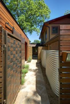 Even the walkway to the carport can be a beautiful space, as evidenced by this Austin, Texas, home, which incorporates a gate of woven raw steel and a metal-clad sliding barn door. Project: Private Residence, Austin, Texas; Architect: Gregory Thomas, Jacksonville, Fla.
