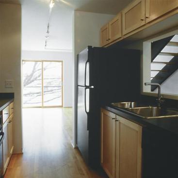 The open floor plan was designed to attract urban professionals and empty-nesters to the townhomes, which are located on the light-rail line connecting the airport and downtown. Kitchen countertops are an Italian laminate.
