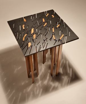 The Tind table combines a water jet-cut steel top with bamboo legs that seem to have been extruded through it.
