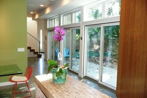 An 18-foot span of sliding doors in the family room and dining room lets in light and provides views of the side yard. During the summer, roof overhangs keep the home from overheating; during the winter, the sun warms the concrete floor. The breakfast bar is made from Weyerhaeuser Parallam.