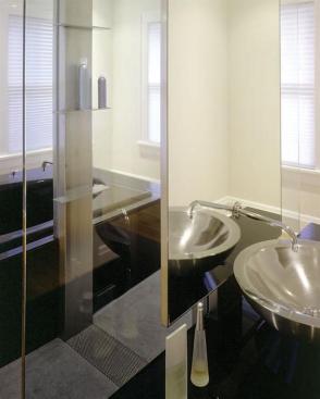 A long trench drain with a perforated stainless cover prevents water overflow in the open shower.