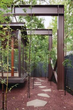 Bamboo stands and a truss canopy create a sense of journey to the entryway.