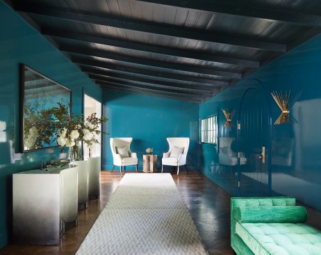 The deep blue foyer with the Scala Luxury console and Niche Interiors-designed green velvet bench creates a dramatic, yet contained, entrance.