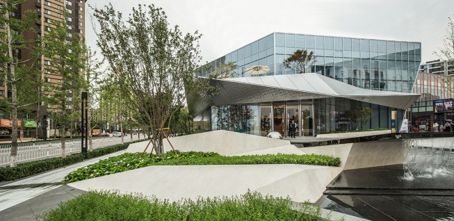 Plants and parasols peek from behind the ribbon, revealing glimpses of the second floor balcony.