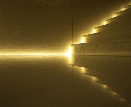 A marble staircase connects all four levels of the spa. A concealed cove along the side of the stairs with linear LEDs takes advantage of the rich, reflective surface of the marble to create a luminous effect.
