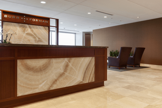 Reception desk and partition in ViviStone Cream Onyx glass with Pearlex finish at Burr & Forman, Orlando, Florida