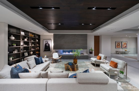 Modern dining room and bar with sliding glass walls open to Los Angeles city views at Hollywood Hills home.