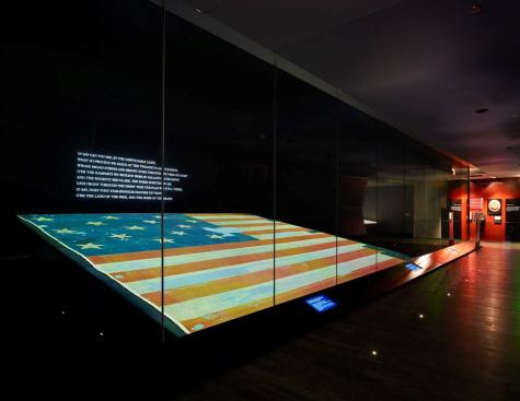 The Star-Spangled Banner, a national treasure and the central artifact of the Smithsonian's National Museum of American History, is displayed on a table with a slight incline for easy viewing in a carefully fabricated two-story high climate controlled case. Given the preservation requirements of minimized exposure to light, the lighting solution was to provide a uniformly illuminated level of one footcandle across the entire artifact. This is achieved with a single source of light that is carefully calibrated to maintain uniform light levels.