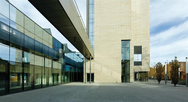 The+eastern+courtyard%2c+with+concrete+pavers+designed+to+mimic+the+shape+of+the+building%e2%80%99s+stone+block%2c+can+be+used+for+casual+gatherings+or+performances.+A+bridge+overhead+connects+a+roof+terrace+atop+the+theater+volume+to+the+third+floor+of+the+arts+tower.