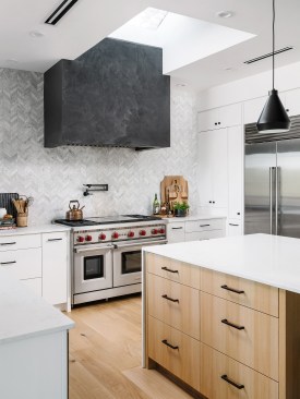 A Skylight Illuminates a Venetian Plaster Clad Range Hood providing Texture and Colore