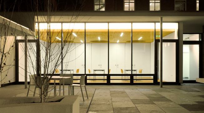 View from the garden into the West community room. The community rooms use direct linear fluorescent and linear fluorescent cove lighting.