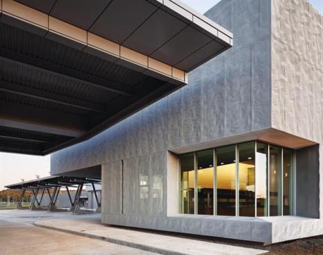 Most of the building's surfaces are clad in a custom-designed rainscreen. Expanded-aluminum mesh (with 50 percent porosity) was stamped in a solid-aluminum press (milled with a custom pattern) to give the mesh a crumpled texture that mimics the surface of the granite boulders found on the site. The panels were designed not only as a nod to the landscape, but also to provide important security. Fixed to stucco exterior walls with stainless steel brackets, the panels conceal window openings but still permit a view out for the officers inside. During the day, the sunlight reflecting off the aluminum makes the concealed windows nearly undetectable to drivers passing through, while still admitting daylight. But at dusk, or in shaded areas such as those under the vehicle canopies, the interior lights make the windows visible.