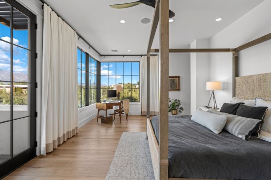 The new master bedroom is abundant with light coming through the large corner window and door leading to the exterior wrap around balcony, The ceiling now has recessed lighting, and the room feels open and spacious.