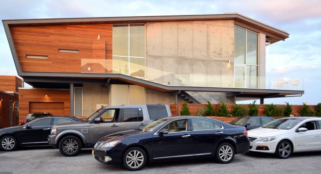 Seen from the side, the home's roof slopes up toward the beach.