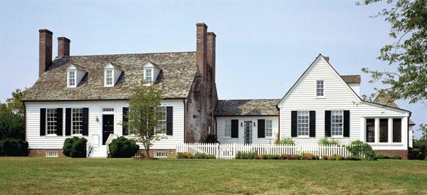 A hyphen (bottom) links the new additions to the original house (left, in 1939). The weathered brick chimney wall, left in its natural state, reveals the layers of history embedded in the project.