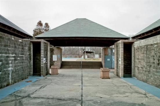 Over the years, large cracks formed in some of the concrete walls, especially at the points directly under the drip line of the roof. The concrete block discolored, and the floor slabs heaved and buckled over time.