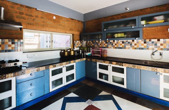 Kitchen wood work are all yesteryear window and ventilator shutters. A riot of  colours and patterns are created by mixed tile, and material.