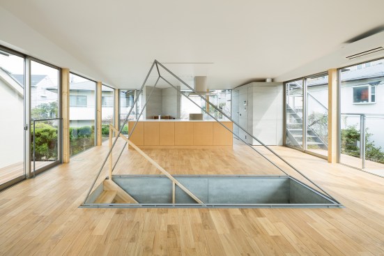 Living and dining are separated by a triangular stair railing