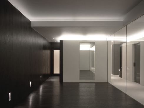 The gym is illuminated by cold cathode lighting at the perimeter ceiling coffers and low-level halogen floor washers, which provide a bright indirect light for 'high-energy' workouts, or low-level lighting for yoga. The monolithic limestone volumes that house the sauna, steam room, and showers are also used to uplight the ceilings in both the gym and the dressing area.