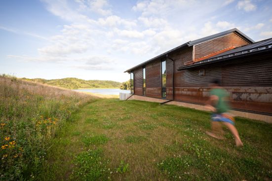 The roof forms mimic the hill beyond.