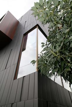 The corner of the home shows a detail of the custom-patterned zinc rain screen, which creates a breathable air space that prevents heat transfer from the outside to the inside.