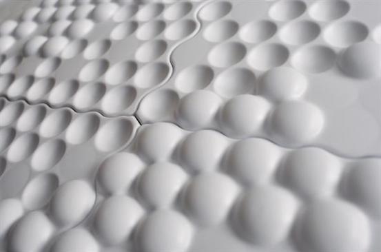 All panels are joined via a serpentine seam that weaves between the dots on the adjacent tiles so as not to disrupt the overall effect of the vacuum-formed surface