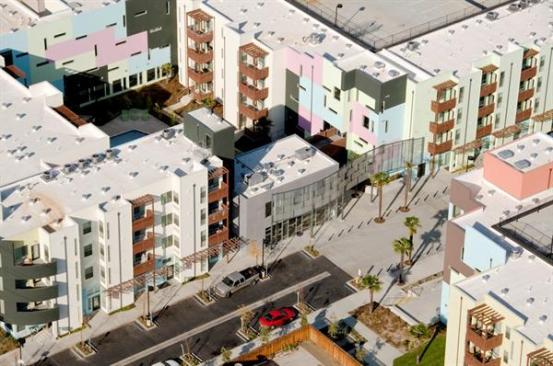 An aerial view the the project, looking down at the palm-lined paseo that bisects it.