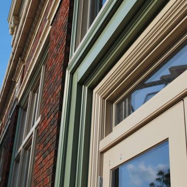 Architect: Susan Richards Johnson, Susan Richards Johnson & Associates, Inc., Kansas City, MO &nbsp; A system of built-up Marvin aluminum stock mouldings at the main entry re-created the proportion and complexity of the door opening which originally was built with limestone and decorative glazed terra cotta.