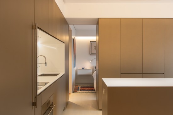 In the bedroom, the owners repurposed and repainted their existing bed. But we designed and built custom floating nightstands for a tailored look. Leveraging an existing beam, we created a light cove and installed wall-mounted reading lamps to offset the lack of recessed lighting.