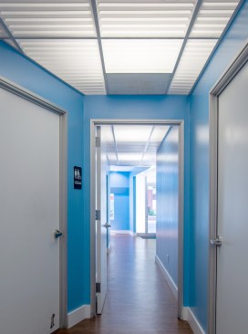 The white and blue décor with luminous ceilings extends throughout the West LA studio for a unified look.