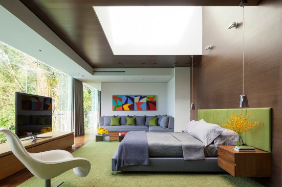 Modern luxury Beverly Hills home bedroom design with skylight and glass wall view.