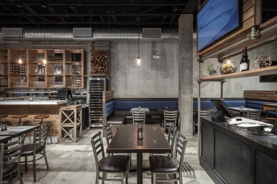 Fire wood, ingredients and bottles of wine occupy the scaffold screens that define dining spaces.
The nostalgic effect of these scaffolds, along with the careful treatment of details, such as the pipe fittings, rough sawn shelving and artful lighting, help manifest the brand identity spatially.
