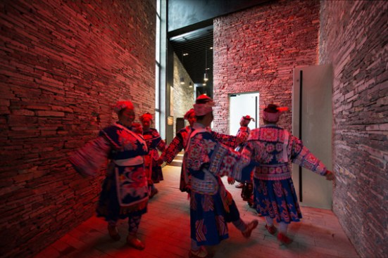 Miao minority girls dancing under a red skylight