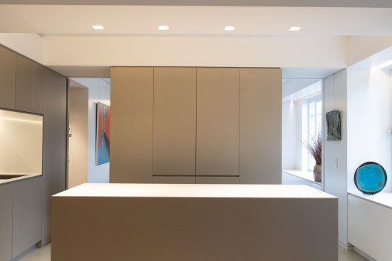 The appliance garage hides all the clutter for the minimalist owners. Two pocket doors in the volume can be closed for separation to the bedroom, or opened for the reading of one larger space. The appliance garage cabinet doors also can fully pocket into the cabinet for ease of use. Recessed finger pulls are used throughout the apartment for a super clean, minimal look without any hardware.