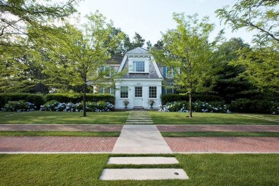 Low-profile granite pavers cross the driveway, connecting the pool and guesthouse.