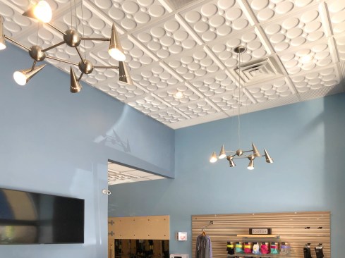 At the second location in Tarzana, the decorative ceiling extends throughout the studio, including the merchandise room, which is lit by contemporary-style direct illumination chandeliers.