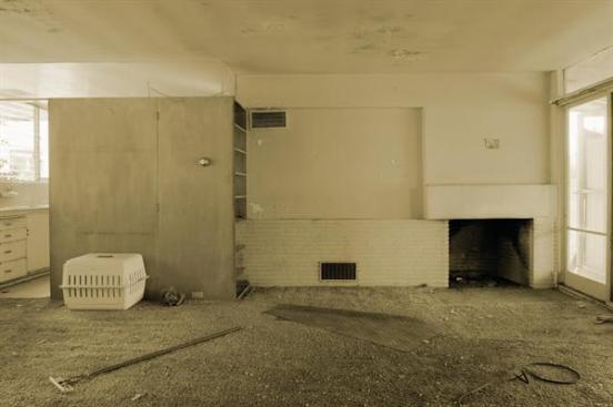 Living room before. Ehrlich forensically reconstructed and refinished built-ins and furniture and restored the fireplace.