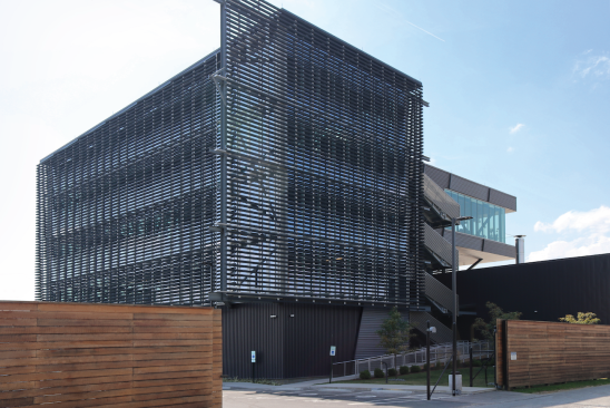 Blackened wood louvers over glass create full transparency and panoramic views in the Manufacturing Atrium. The blackened wood honors the charred barreling process and the full-glass atrium allows for full transparency as the distillery’s owner requested.