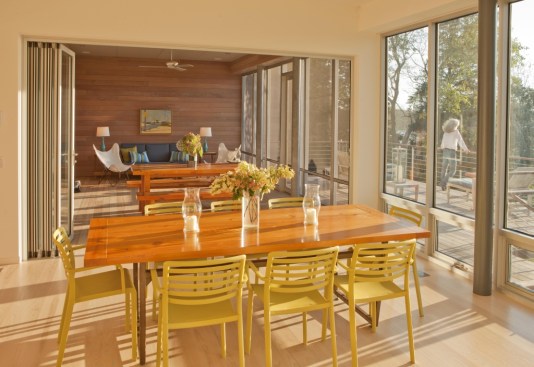 The main living space opens through a bi-folding wall of glass to a large screened porch