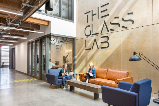 Second-floor office suites feature storefront glass facing a main hall and lobby area to bring in natural light while also creating a sense of connectivity that supports the concept of collaboration between tenants.